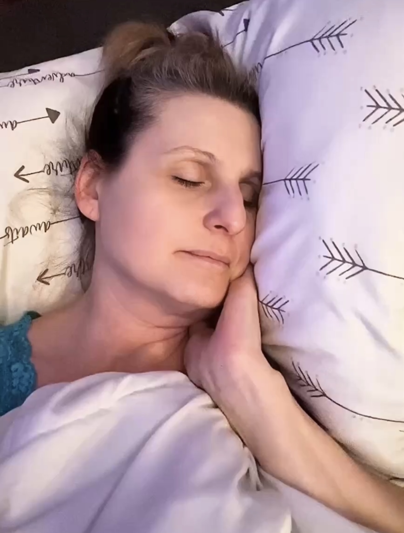 Woman peacefully sleeping in bed, representing the importance of rest and sleep during menopause